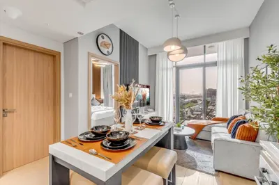 a kitchen and living room with a table and a couch at 1BR Royal Bedroom with Pool & Gym Free in Dubai