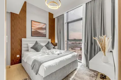 a bedroom with a white bed and a large window at 1BR Royal Bedroom with Pool & Gym Free in Dubai