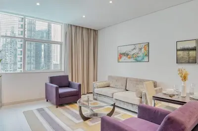 a living room with a couch and a table and chairs at PVH - Refined 1BR in Business Bay - Cour Jardin in Dubai