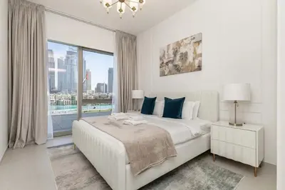 a white bedroom with a bed and a large window at TRPS - Grande, Downtown - Full Burj Khalifa View, Luxury Furnished - Close to Dubai Mall in Dubai