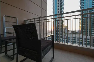 a chair on a balcony with a view of a city at Stylish 1BR in Downtown - 5 Min to Burj & Mall in Dubai