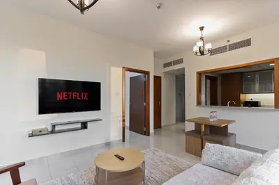 a living room with a television on a wall at Stylish 1BR in Downtown - 5 Min to Burj & Mall in Dubai
