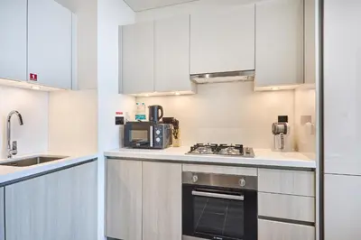 a kitchen with white cabinets and a stove top oven at STAY BY LATINEM Luxury 1BR Holiday Home CA 1509 Near Downtown in Dubai