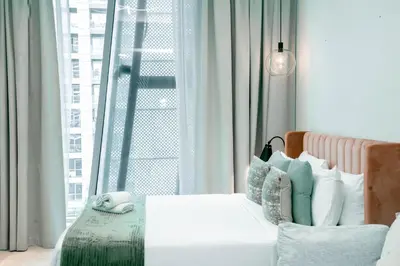 a bedroom with a white couch and a window at Stylish Stay with Rooftop Pool and Gym, Close to Dubai's Top Sights in Dubai