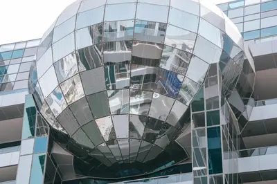 a glass building with its reflection in the window at Stylish Stay with Rooftop Pool and Gym, Close to Dubai's Top Sights in Dubai