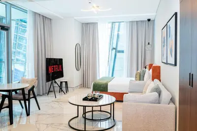 a hotel room with a bed and a living room at Stylish Stay with Rooftop Pool and Gym, Close to Dubai's Top Sights in Dubai