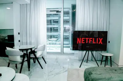 a living room with a television with the words netflix at Stylish Stay with Rooftop Pool and Gym, Close to Dubai's Top Sights in Dubai