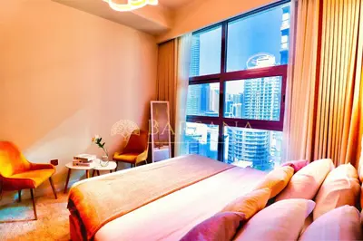 a bedroom with a bed and a large window at Barsana - Lavish 3BR Retreat - Marina & Sea Views in Dubai