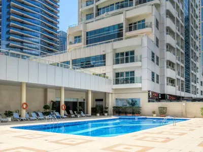 a swimming pool in front of a building at The Smart Concierge - Marina view in Dubai