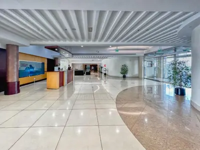 an empty lobby with a person walking in a building at The Smart Concierge - Marina view in Dubai