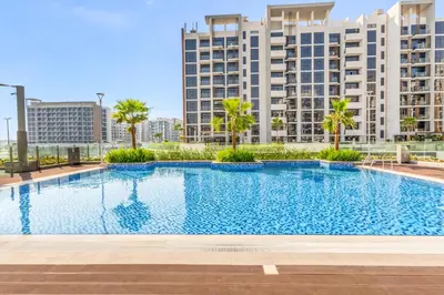 a large swimming pool with buildings in the background at Elite Apartments in Meydan in Dubai