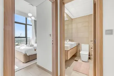 a bathroom with a toilet and a sink and a bed at Elite Apartments in Meydan in Dubai