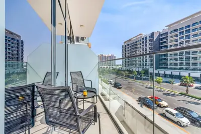 a balcony with two chairs and a table at Elite Apartments in Meydan in Dubai