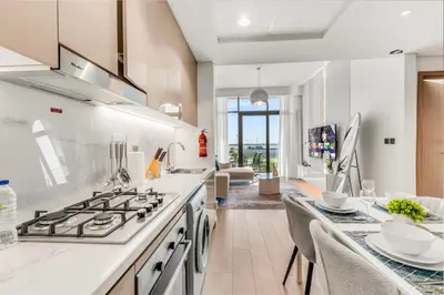 a kitchen with a stove and a dining room at Elite Apartments in Meydan in Dubai
