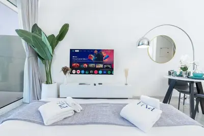 a bedroom with a bed with a tv on the wall at PVH - Serene Studio with Skyline View - Carson B in Dubai