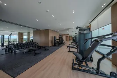 a gym with treadmills and machines in a building at Newly Furnished Studio Haven in Binghatti Azure in Dubai