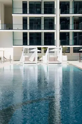 a swimming pool in front of a building at Newly Furnished Studio Haven in Binghatti Azure in Dubai