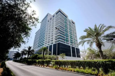 a tall building with a road in front of it at Newly Furnished Studio Haven in Binghatti Azure in Dubai