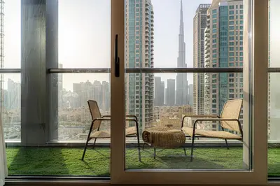 two chairs in a window with a view of a city at Luxury 1 BR At The Sterling in Dubai