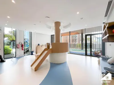 a living room with a staircase and large windows at Comfort Studio in Meydan With Gym, Pool & Parking in Dubai