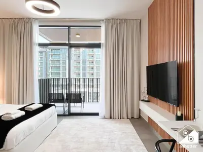 a hotel room with a bed and a large window at Comfort Studio in Meydan With Gym, Pool & Parking in Dubai