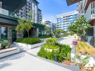 a courtyard in a building with trees and plants at Comfort Studio in Meydan With Gym, Pool & Parking in Dubai