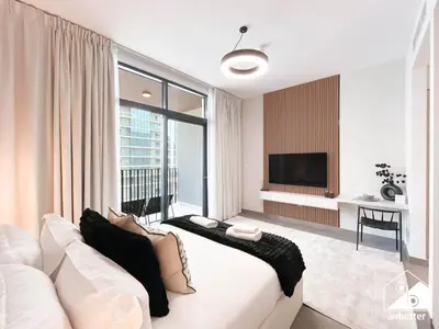 a living room with a white couch and a large window at Luxury Studio in Meydan With Gym, Pool Access in Dubai