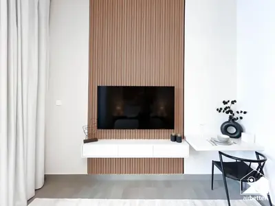 a living room with a flat screen tv on a wall at Luxury Studio in Meydan With Gym, Pool Access in Dubai