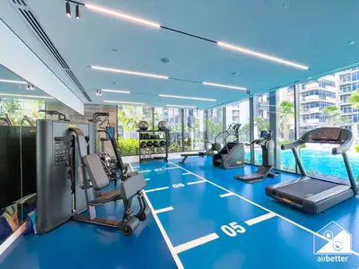 a gym with cardio equipment and a swimming pool at Luxury Studio in Meydan With Gym, Pool Access in Dubai