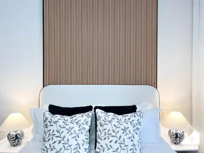 a bedroom with a white bed with blue and white pillows at Luxury Studio in Meydan With Gym, Pool Access in Dubai