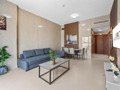 a living room with a blue couch and a table at BLVD - Scenic View Stay with Pool and Gym Access in Dubai