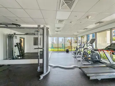 a gym with several treadmills and elliptical machines at BLVD - Scenic View Stay with Pool and Gym Access in Dubai