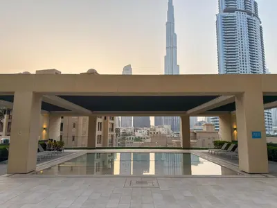 a building with a pool in the middle of a city at 4BR Burj & Fountain View Luxe in Dubai