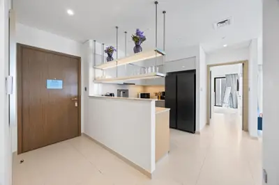 a kitchen with white walls and a wooden door at 4BR Burj & Fountain View Luxe in Dubai
