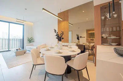 a dining room and living room with a table and chairs at Chic 2BR Flat in Park Lane Dubai in Dubai