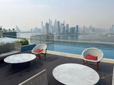 a balcony with tables and chairs and a view of a city at FullSeaView-RoofTopPool Free Private WestBeachAccess in Dubai