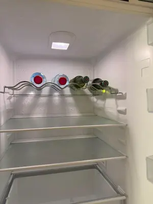 a refrigerator with four glass bottles on a shelf at FullSeaView-RoofTopPool Free Private WestBeachAccess in Dubai
