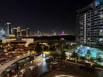 a city skyline at night with a tall building at FullSeaView-RoofTopPool Free Private WestBeachAccess in Dubai
