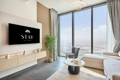a living room with a tv and large windows at STAY BY LATINEM Luxury 1BR Holiday Home CB 3607 Near Burj Khalifa in Dubai
