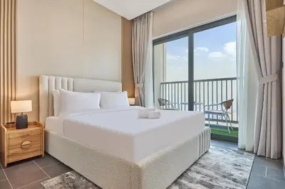 a bedroom with a large white bed and a balcony at STAY BY LATINEM Luxury 1BR Holiday Home CB 3607 Near Burj Khalifa in Dubai