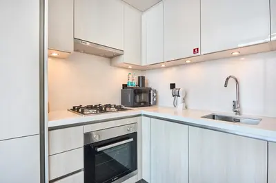 a kitchen with white cabinets and a sink at STAY BY LATINEM Luxury 1BR Holiday Home CB 3607 Near Burj Khalifa in Dubai