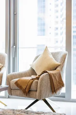a chair with a blanket on it in a living room at Fabulous 2 BR - Paramount Midtown in Dubai