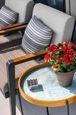 a table with a pot of red flowers on it at Fabulous 2 BR - Paramount Midtown in Dubai