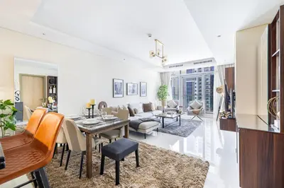 a living room with a table and a dining room at Fabulous 2 BR - Paramount Midtown in Dubai