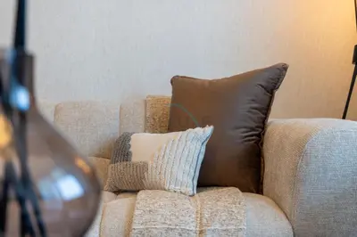 a brown couch with a brown pillow on it at Canal and Burj Khalifa Views, Few Minutes Drive to Downtown Dubai and 15 Minutes Drive to Kite Beach, Binghatti Canal, Business Bay by Deluxe Holiday Homes in Dubai