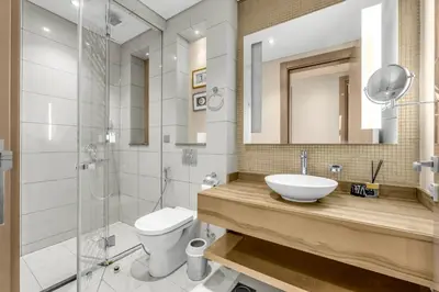 a bathroom with a sink and a toilet and a shower at 2BR Midtown Gem - Luxurious Apartment with Balcony in Dubai