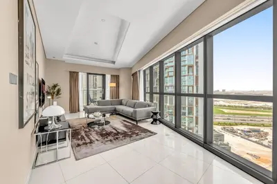 a living room with a couch and large windows at 2BR Midtown Gem - Luxurious Apartment with Balcony in Dubai