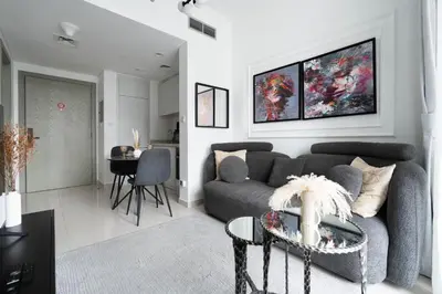 a living room with a couch and a table at KeyRock - Modern 1BR in Zada with Pool & View in Dubai