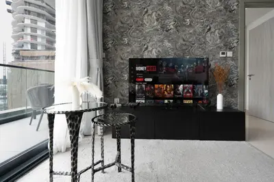 a living room with a table and a tv at KeyRock - Modern 1BR in Zada with Pool & View in Dubai