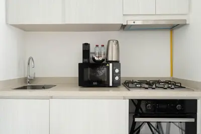 a kitchen counter with a microwave and a stove at KeyRock - Modern 1BR in Zada with Pool & View in Dubai